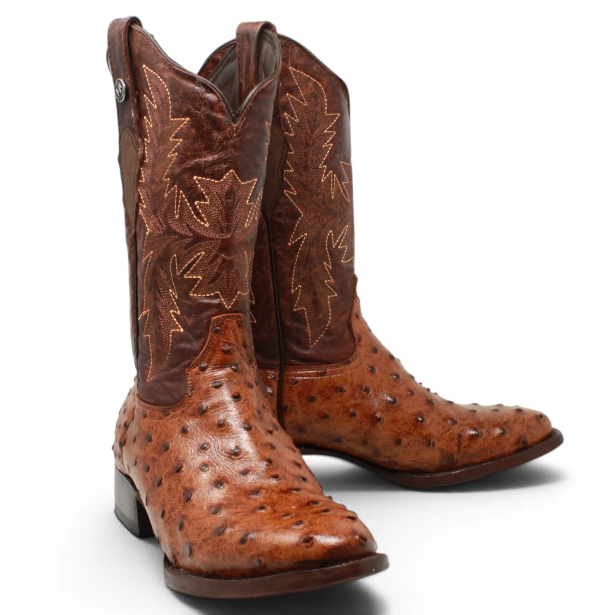 Black Label men's western cowboy boots featuring a cognac ostrich print leather foot, dark brown embroidered leather shaft, square toe, leather sole, and traditional cowboy heel. Handcrafted western boots with exotic-inspired texture and classic ranch styling. pair
