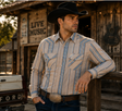 Camisa western para hombre de manga larga con diseño de rayas verticales y bolsillos frontales, combinada con jeans y sombrero vaquero negro.