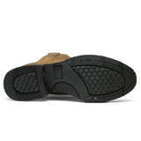 Bota de trabajo para hombre de piel graso color Shedron con suela de hule, usada en ambiente de taller con jeans y guantes de trabajo. Suela