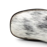 Bota vaquera para dama de pelo de vaca natural en tonos blanco y negro con punta cuadrada, tubo negro de piel con grabado cincelado floral y suela de cuero artesanal. Cada par presenta un patrón de pelo único. Toe 
